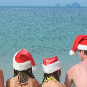 FamÃ­lia na beira do mar usando gorros natalinos