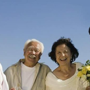 Foto de uma famÃ­lia junto com os noivos em um casamento na praia, todos na beira do mar, felizes. Imagem para o blog da Pousada dos Sonhos em JurerÃª, FlorianÃ³polis, que tambÃ©m realiza casamentos Ã  beira do mar.