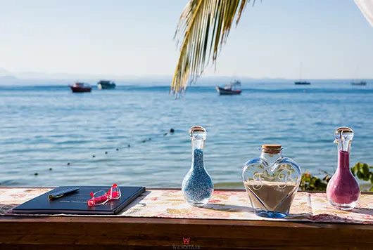 Garrafinhas decoram o ambiente de casamento frente ao mar de Jurerê em Florianópolis, Santa Catarina. 