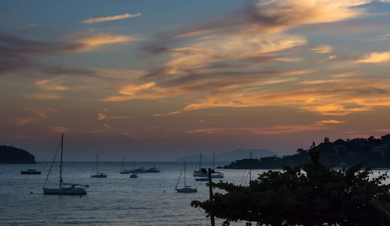 Imagem da beira do mar com barcos no entardecer em Florianópolis, Santa Catarina
