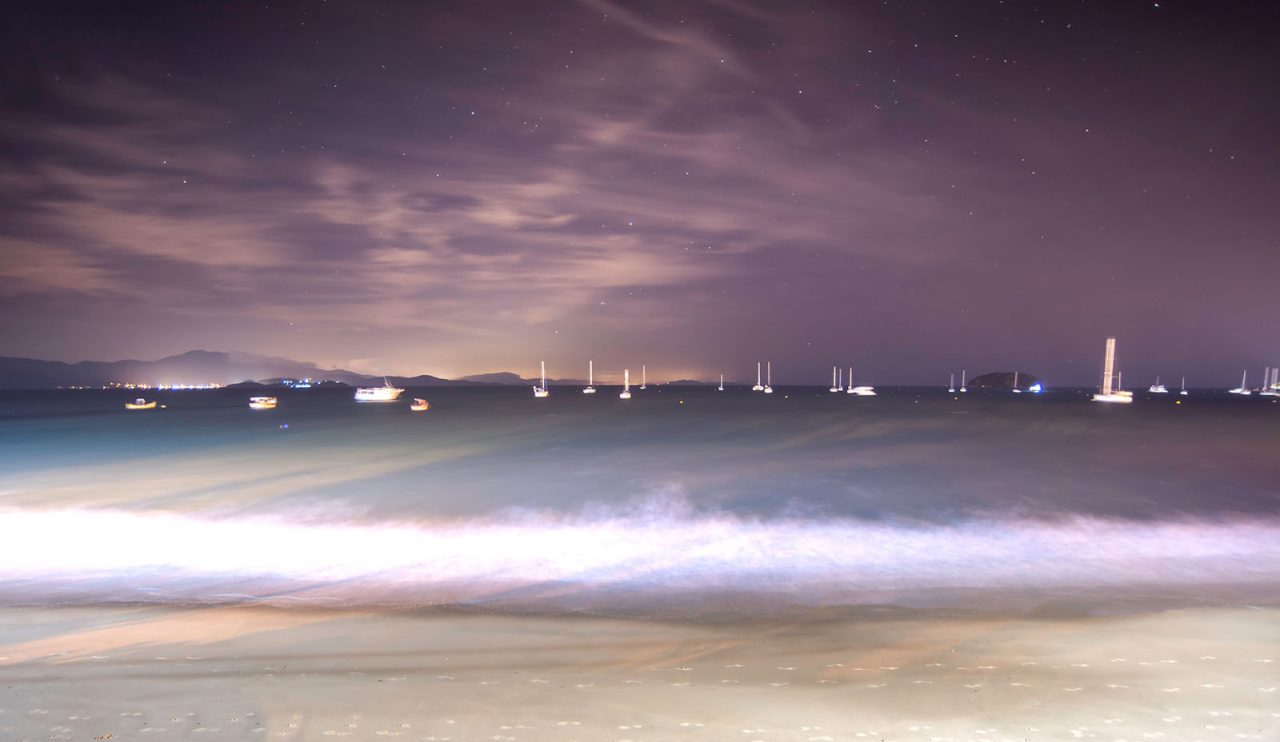 Momento mágico na noite à beira-mar com barcos ao fundo no oceano em Florianópolis, Santa Catarina