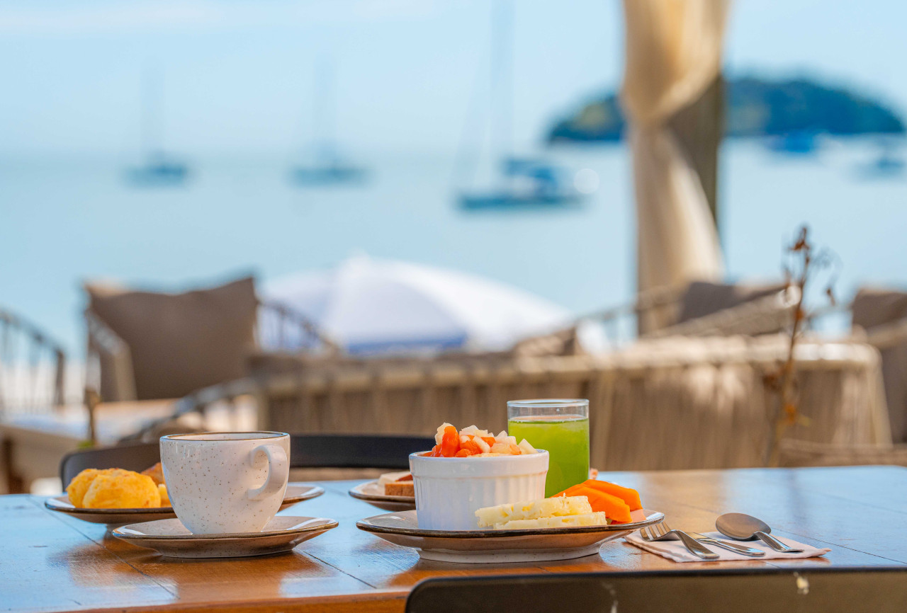 Imagem do café da manhã servido de frente para o mar na Pousada dos Sonhos
