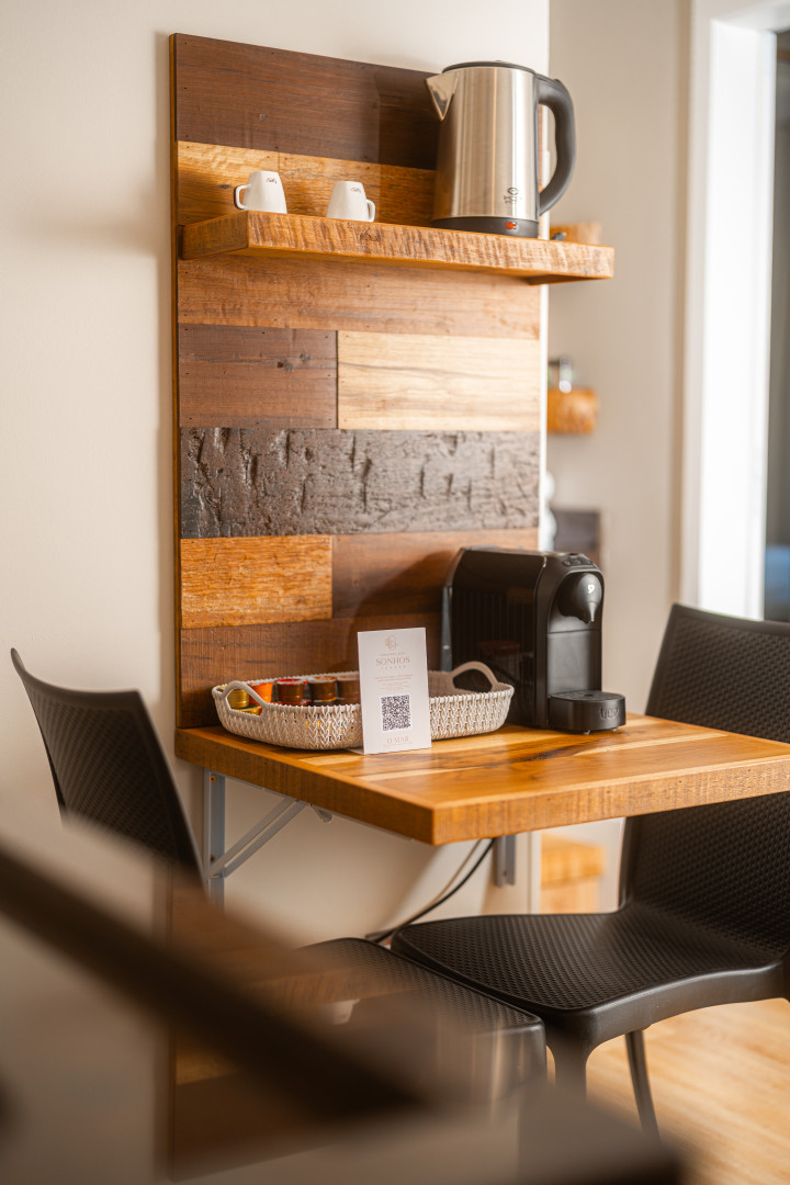 Imagem da mesa com cadeiras da sala do apartamento 1 quarto vista lateral da Pousada dos Sonhos